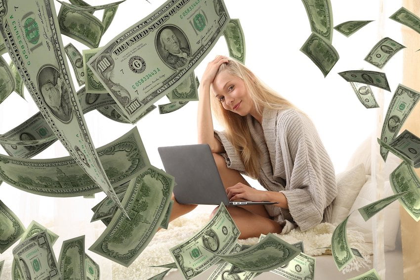 woman with dollar bills flying around her